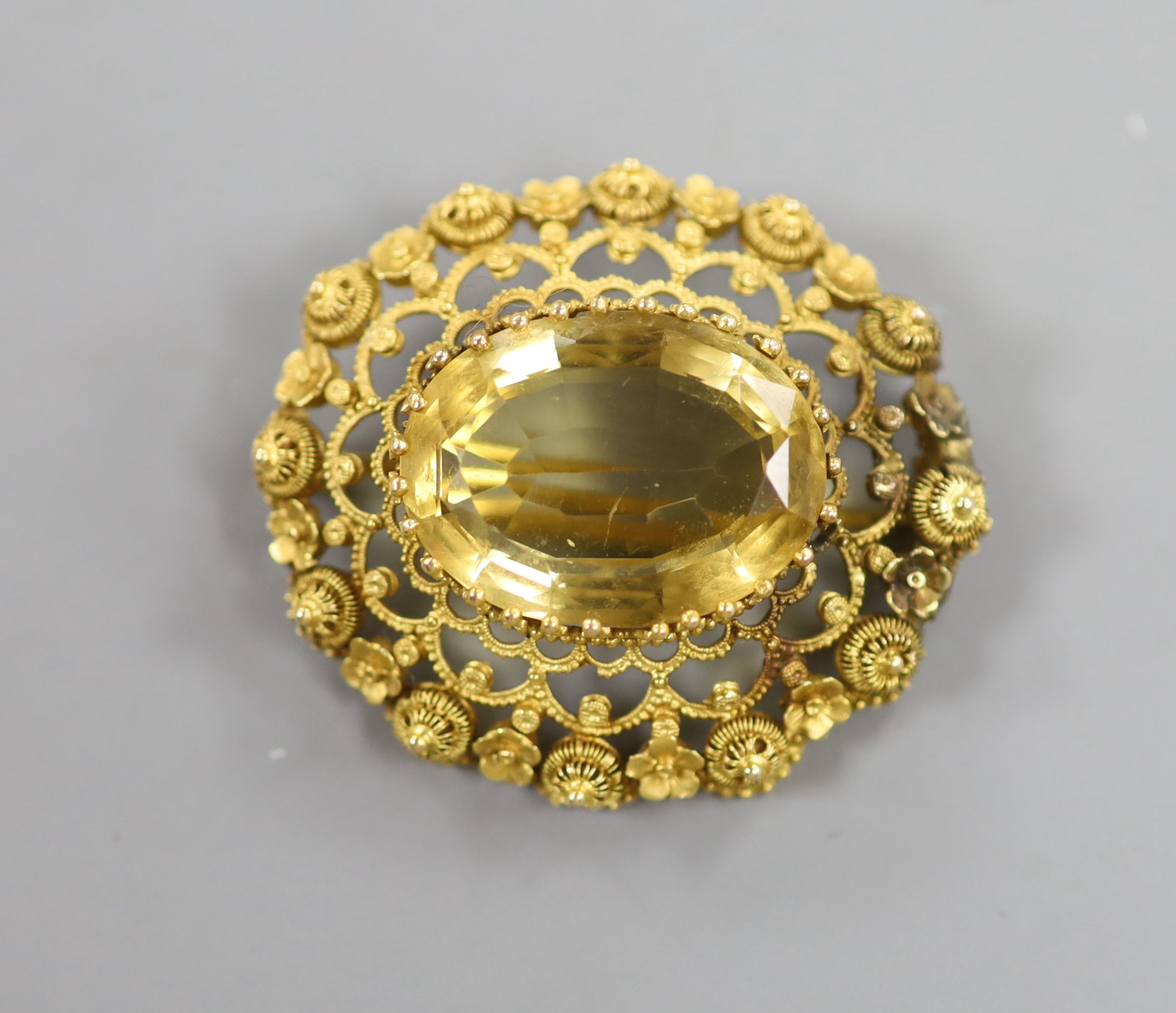 A late Victorian yellow metal and citrine set oval brooch, with canetile work decoration